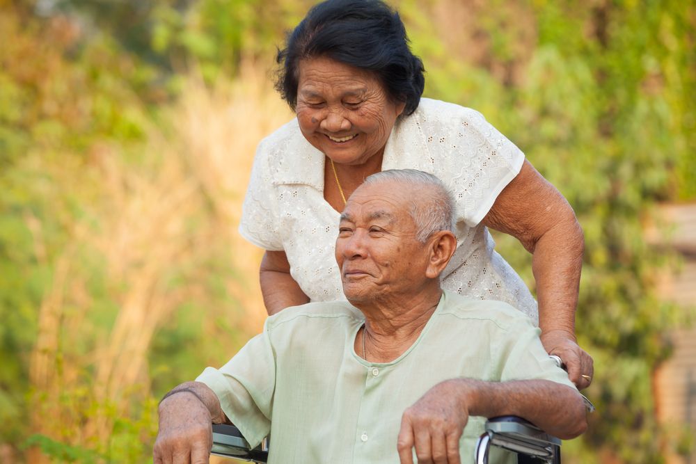 asian couple by the wheelchair is one of priorities during monsoon season in malaysia