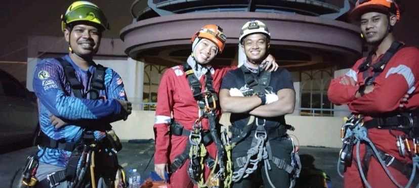 normalia, Malaysia' spider woman with male colleagues