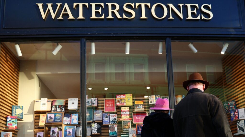 A couple look at books in the window display in a branch of Waterstones bookshop in Guildford, southwest of London on January 13, 2022. 