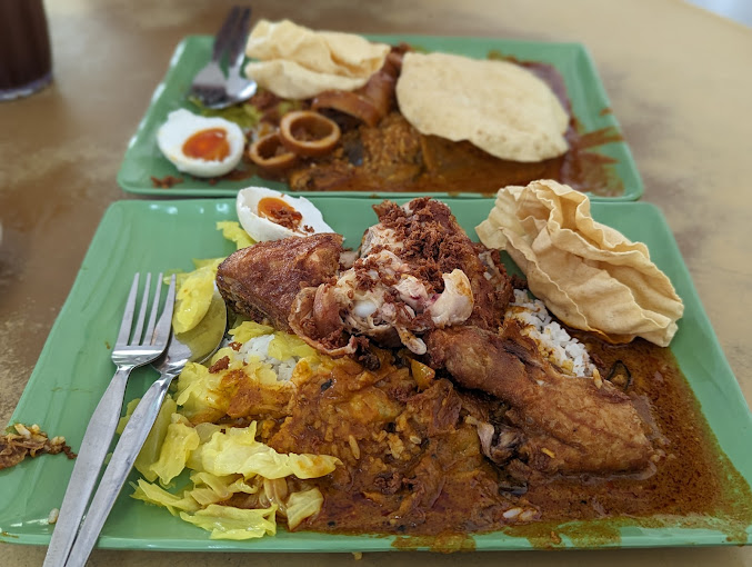 A plate of nasi kandar with chicken and papadom