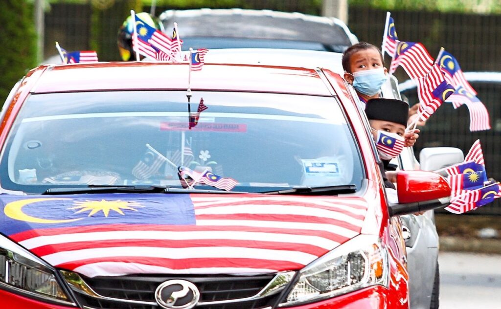 Attaching jalur gemilang on hood of the car