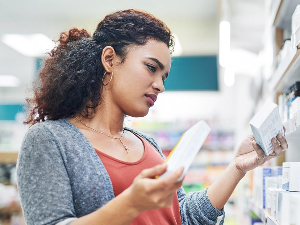 young woman at the pharmacy searching for the right medicine