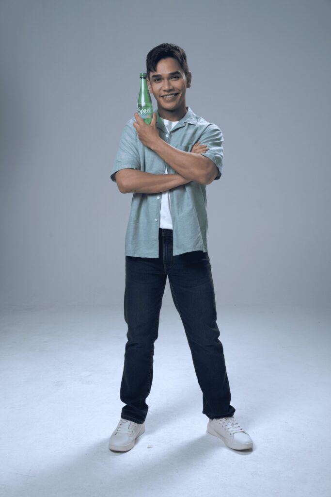 Spritzer ambassador Aedy Ashraf holding a bottle of Spritzer Sparkling