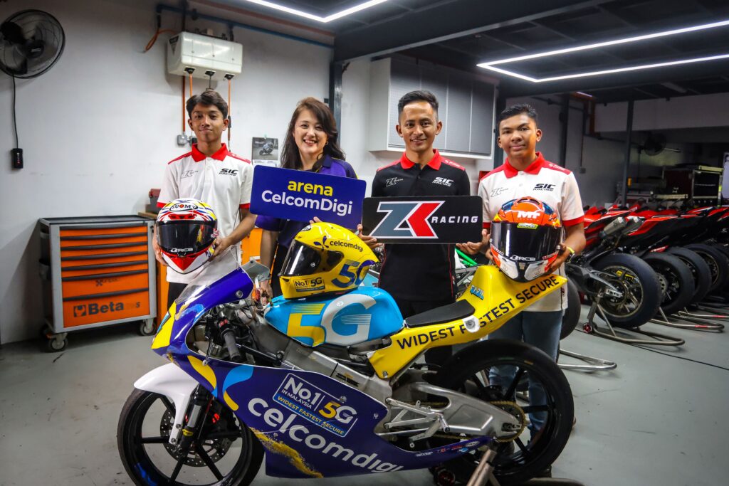 MotoMini Malaysia young riders with CelcomDigi and ZK Racing beside a CelcomDigi 5G race bike
