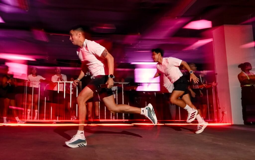 Runners racing in the adidas Hyperrelay 500-metre team relay at LahLahLand, MIECC