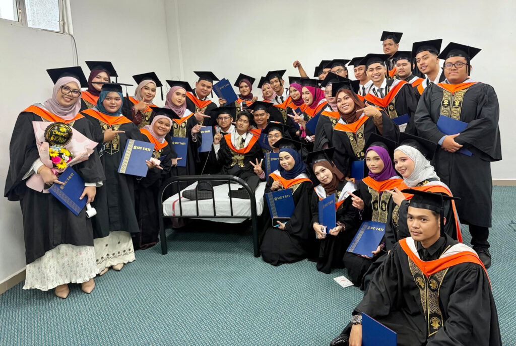 UC TATI graduates gather around Muhammad Afiq for a group photo at the 26th convocation ceremony