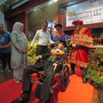 Muhammad Afiq Mohd Hairul Fahmy in a wheelchair with his parents receiving his degree at the UC TATI convocation