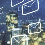 Phishing emails flooding workplace inboxes, illustrated as email icons over a city skyline