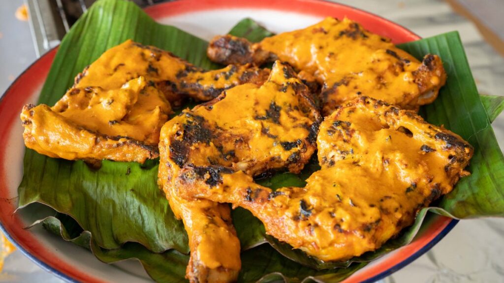 Kelantan ayam percik grilled chicken with coconut sauce on banana leaf