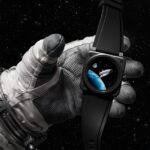 Astronaut glove holding the Bell & Ross BR-03 Space Mission watch in front of Earth