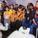Junior Innovathon 2026 students meeting a humanoid robot at CelcomDigi AiX