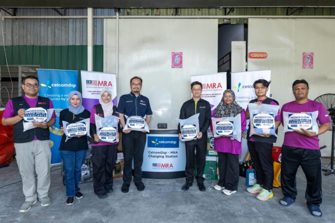 CelcomDigi monsoon preparedness team with Malaysian Relief Agency volunteers holding flood relief kits