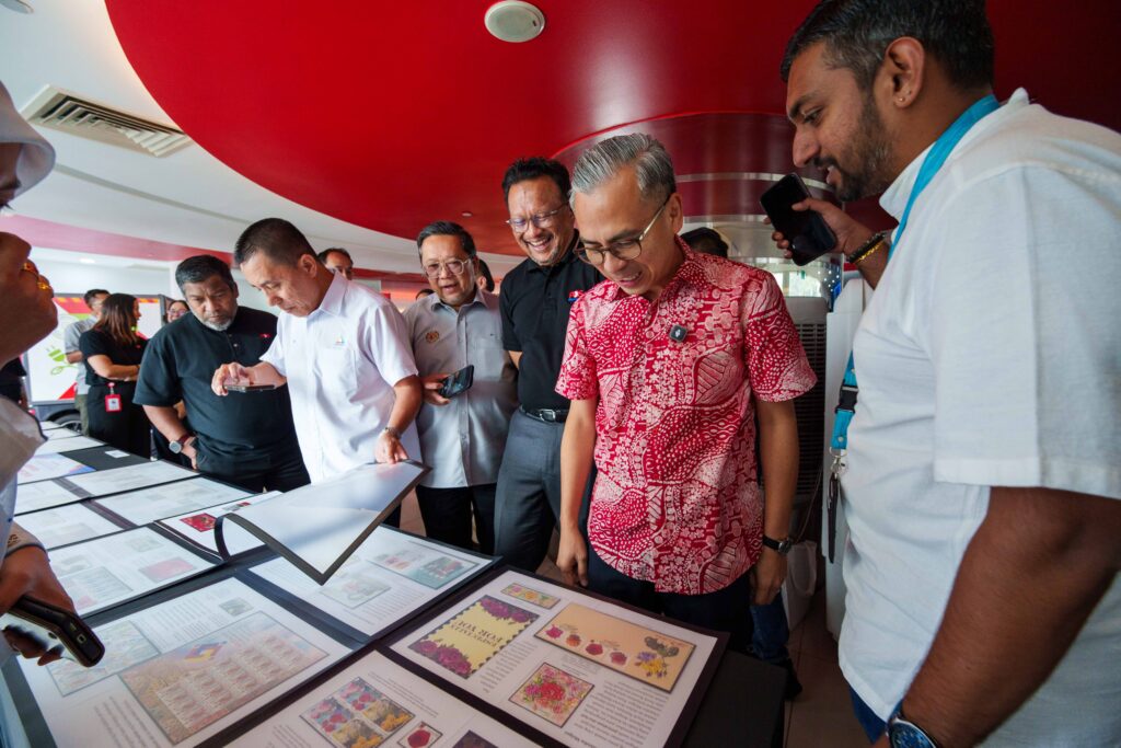 Guests view stamp folio entries at Pos Malaysia World Post Day 2026 celebration