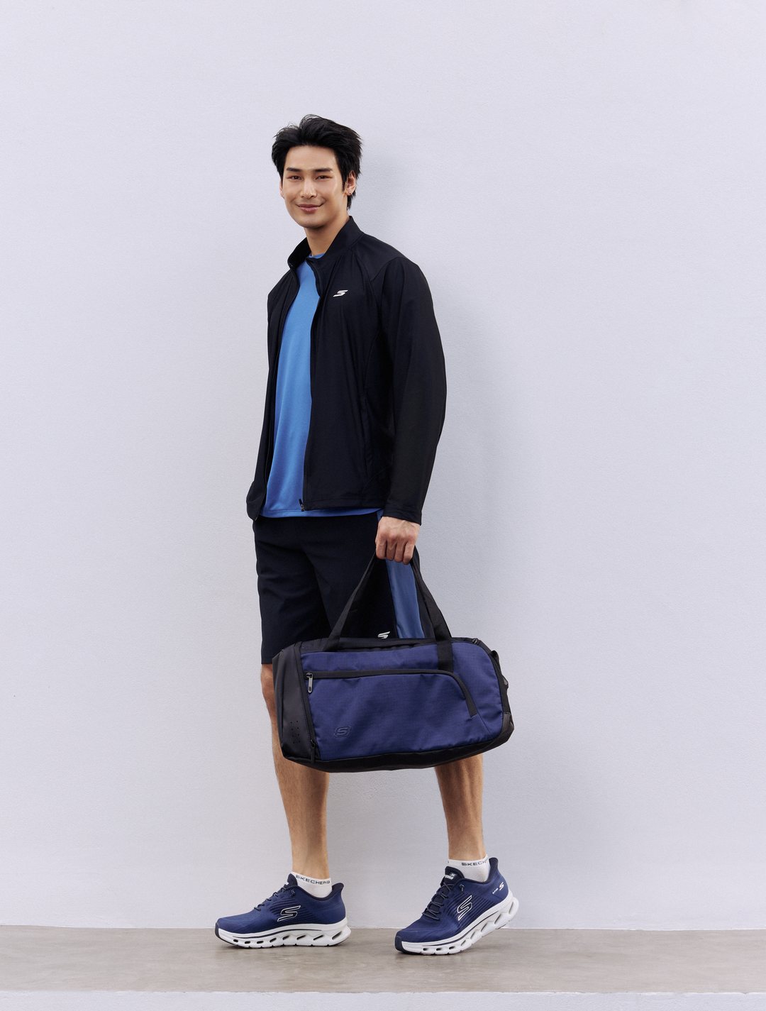 Skechers GOwalk Glide-Step 2.0 in Navy Blue worn with a Skechers jacket and duffel bag